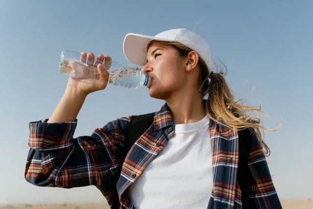 femme qui boit de l'eau dans une bouteille
